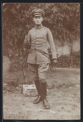 Foto-AK Soldat in Feldgrau Uniform mit Schirmmütze