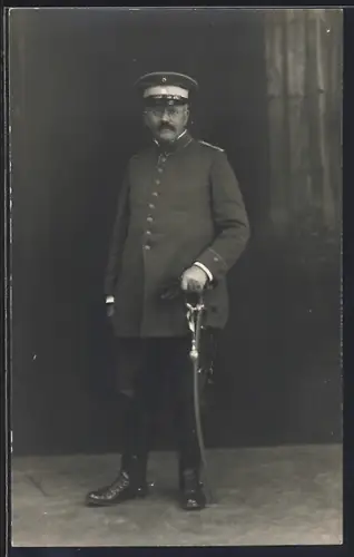 AK Oberleutnant in Uniform mit Säbel und Schirmmütze