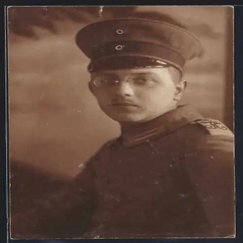 Foto-AK Soldat in Feldgrau Uniform mit Schirmmütze