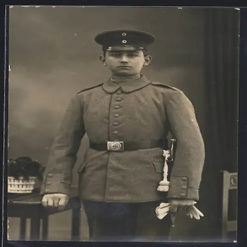 Foto-AK Soldat in Feldgrau Uniform mit Bajonett und Schirmmütze