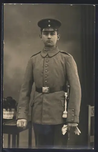 Foto-AK Soldat in Feldgrau Uniform mit Bajonett und Schirmmütze