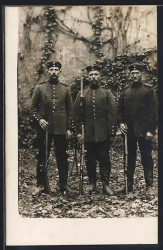 Foto-AK Drei Soldaten in Uniform mit Gewehr und Krätzchen