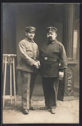 Foto-AK Zwei Soldaten in Uniform mit Schirmmütze