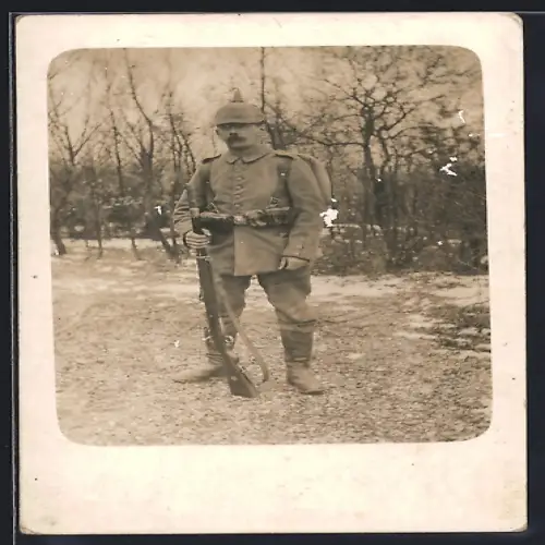 Foto-AK Soldat in Feldgrau Uniform mit Marschausrüstung, Pickelhaube und Gewehr