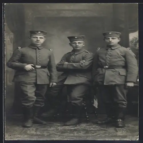 Foto-AK Drei Soldaten in Feldgrau Uniform mit Krätzchen