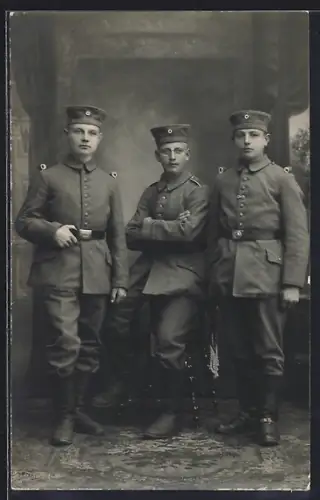 Foto-AK Drei Soldaten in Feldgrau Uniform mit Krätzchen