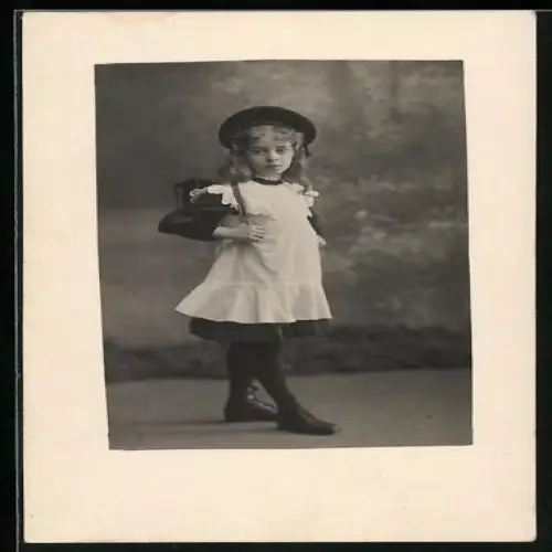 Foto-AK Kleines Schulmädchen im Spitzenkleid in einer Studiokulisse