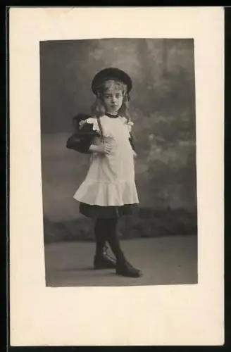 Foto-AK Kleines Schulmädchen im Spitzenkleid in einer Studiokulisse