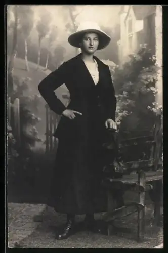 Foto-AK Junge Frau an einer Bank in einer Studiokulisse
