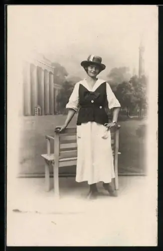 Foto-AK Junge Dame an Bank in einer Studiokulisse