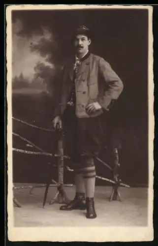 Foto-AK Junger Mann in Tracht in einer Studiokulisse