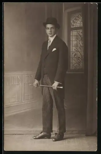 Foto-AK Junger Mann in Anzugjacke in einer Studiokulisse