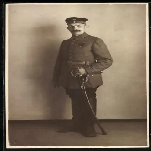 Foto-AK Soldat in Feldgrau Uniform mit Ordensspange alter Art und Säbel