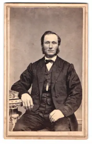 Fotografie J. H. Kent, Brockport / N.Y., Porträt eines sitzenden Mannes im Anzug mit Fliege