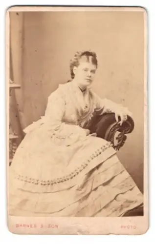 Fotografie Barnes & Son, London, Mile End Road 424, Dame im weissen Kleid auf einem Sessel