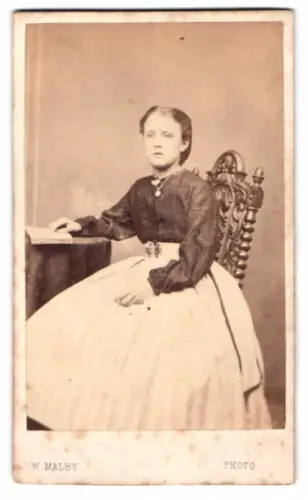 Fotografie W. Malby, London, City Road 155, Sitzendes Mädchen in elegantem Kleid