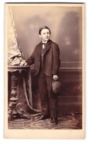 Fotografie H. Th. Hudermann, München, Sonnenstrasse 11, Porträt eines Jungen mit Hut in der Hand