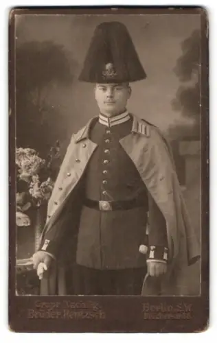 Fotografie Brüder Rentzsch, Berlin, Kochstrasse 36, Gardesoldat in Uniform mit Mantel, Helm mit Rosshaarbusch