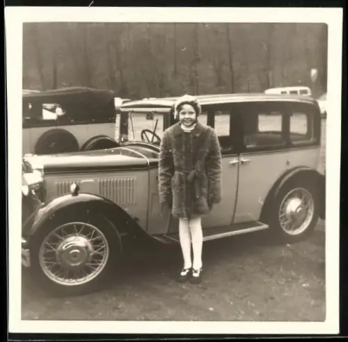 Fotografie Auto Limousine, Mädchen im Pelzmantel neben PKW stehend