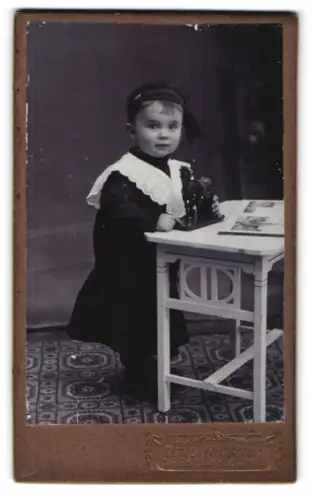 Fotografie Otto Martin, Dresden-Löbtau, Rosenstrasse 2, Kind mit Spielzeugpferd am Tisch