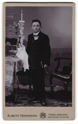 Fotografie Albert Herrmann, Karlsruhe, Durlacher Allee 38, Junger Mann mit Kerze zu seiner Kommunion