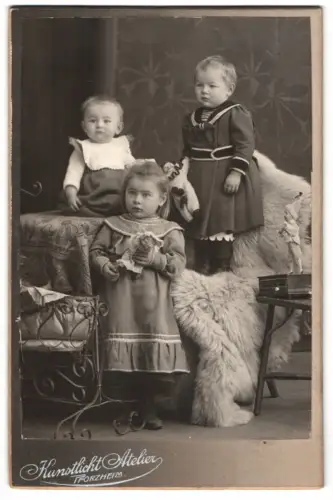 Fotografie Kunstlicht Atelier, Pforzheim, Markt 13, Kinder mit Spieluhr Puppe / Drehorgel auf dem Tisch, Puppen