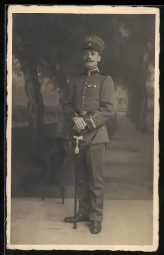 Foto-AK Vize-Feldwebel in Uniform mit Feldspange, Säbel und Schirmmütze