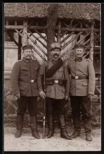 Foto-AK Drei Landwehr-Soldaten in Uniform, 1 mit Gewehr und Marschausrüstung