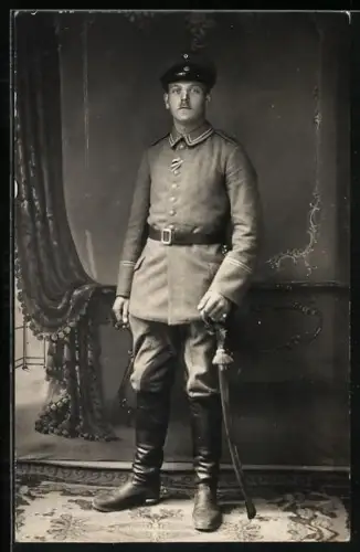 Foto-AK Uffz. in Feldgrau Uniform mit Säbel und Schirmmütze, Band zum EK II 1914