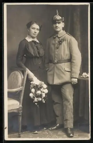 AK Frau mit Soldat in Feldgrau Uniform mit Pickelhaube