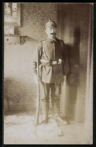 Foto-AK Soldat in Feldgrau Uniform mit Koppeltaschen, Gewehr und Pickelhaube