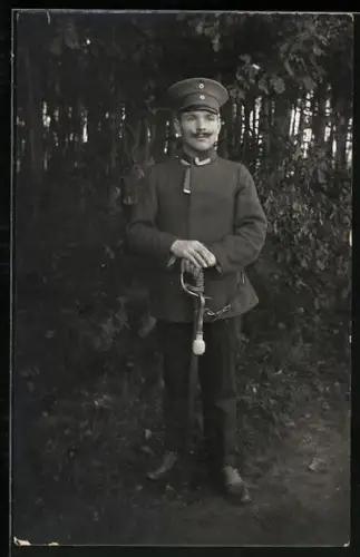 Foto-AK Uffz. in Uniform mit Säbel und Schirmmütze
