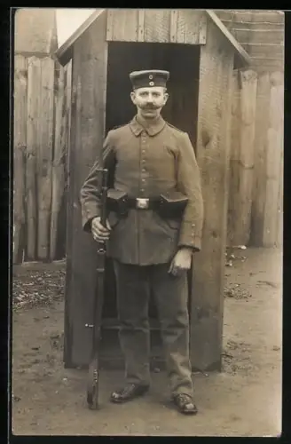 Foto-AK Landwehr-Soldat in Uniform mit Koppeltaschen, Gewehr und Krätzchen