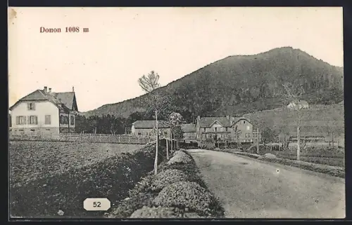 AK Donon, Vue de la route avec maisons et montagne en arrière-plan