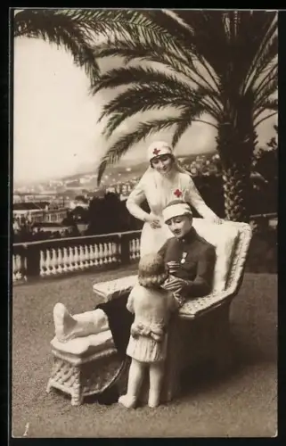 AK Rot Kreuz-Schwester betreut Versehrten mit Kind auf Terrasse mit Palme