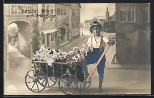 Foto-AK R & K / L: Kleiner Gratulant mit Blumenwagen vor Strassenkulisse, Geburtstagsgruss