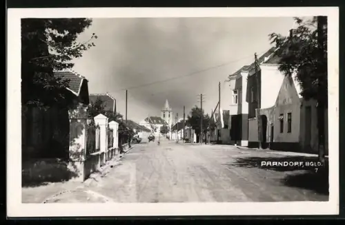 AK Parndorf, Strassenpartie mit Kirche im Sonnenschein