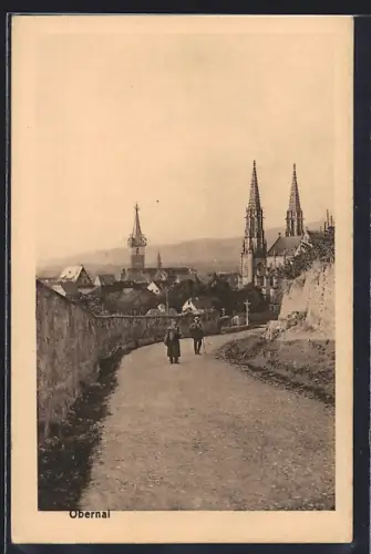 AK Obernai, Vue de la ville avec église et tours depuis un chemin bordé de murs