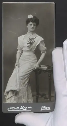 Fotografie Medina, Wien, junge Frau im eleganten Kleid mit Perlenkette und Blume im Haar