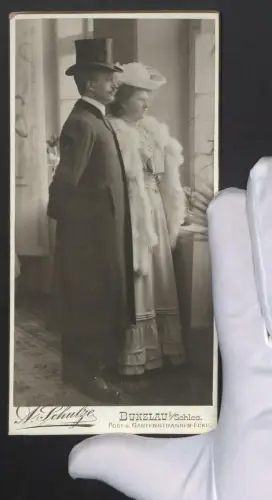 Fotografie A. Schulze, Bunzlau i. Schl., Paar Rudi und Elsa Runke im Mantel mit Zylinder und im Kleid mit weisser Stola