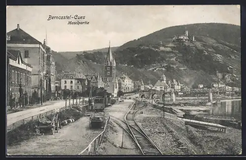 AK Berncastel-Cues, Moselpartie mit Bahn am Ufer, Strasse, Brücke, Turm u. Burg