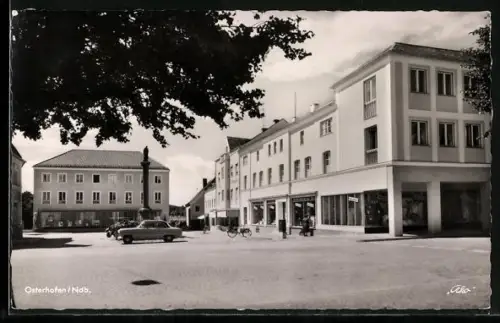 AK Osterhofen /Ndb., Ortspartie mit Denkmal, parkenden Autos und Sparkasse