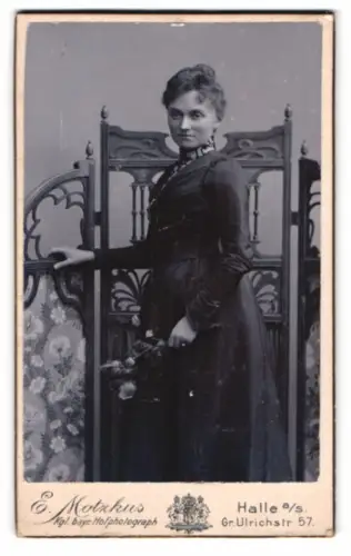 Fotografie E. Motzkus, Halle a/s, Gr. Ulrichstr. 57, elegante Frau mit Blumenstrauss vor einem Paravent
