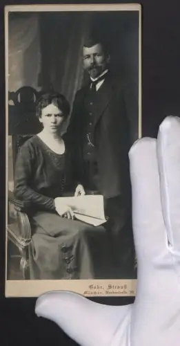 Fotografie Gebr. Strauss, München, Paar im dunklen Anzug und im dunklen Kleid