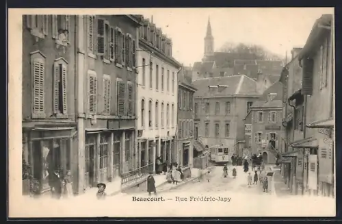 AK Beaucourt, Rue Frédéric-Japy animée avec passants et vue sur le clocher en arrière-plan