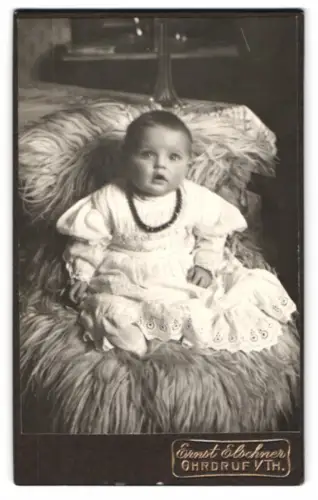Fotografie Ernst Elschner, Ohrdruf, Reinhardsbrunnerstr. 42, Kleinkind auf flauschigem Sessel
