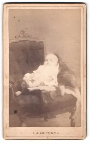 Fotografie J. Leitner, Bruck a. M., Hauptplatz 22, Kleinkind auf antikem Sessel
