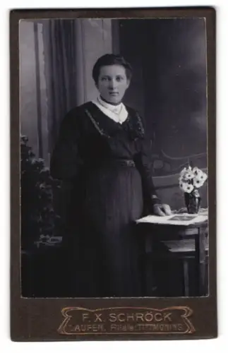 Fotografie F. X. Schröck, Laufen, Frau in dunklem Kleid mit Blumenarrangement