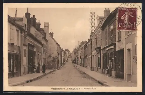AK Villeneuve-la-Guyarde, Grande-Rue animée avec passants et maisons anciennes