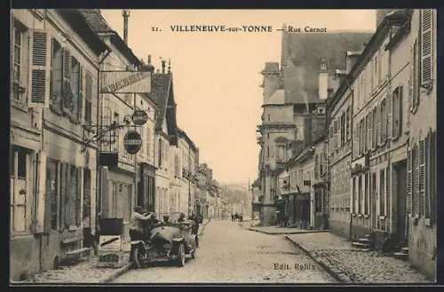 AK Villeneuve-sur-Yonne, Rue Carnot avec voitures et bâtiments historiques